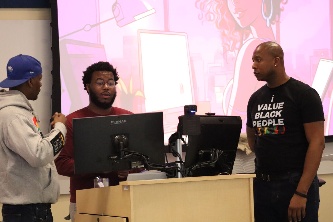 Intergenerational gathering of Black men sharing care and conversation.